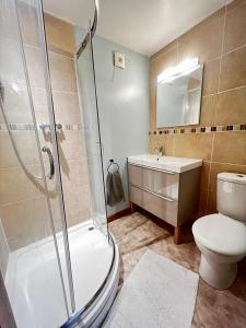 a bathroom with a shower and a toilet and a sink at Dartford Cozy One-Bedroom Flat - Sleeps 2 in Sutton at Hone +12 photos