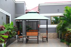a patio with a table and chairs under an umbrella at Erliz villa in Kumasi