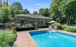une piscine devant une maison dans l'établissement Family friendly place with pool and jacuzzi, à Penetanguishene