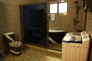 a bathroom with a shower with a tub and a toilet at Erliz villa in Kumasi +4 photos