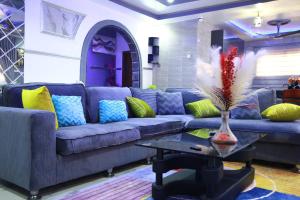 a living room with a blue couch and a table at Erliz villa in Kumasi