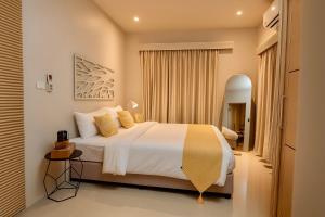 una camera da letto con un letto grande e uno specchio di Tulum Villa Resort Koh Samui a Nathon Bay