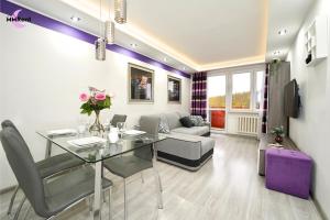 a living room with a glass table and a couch at MMRent Apartament CityLight in Gdańsk