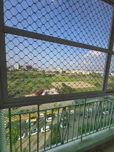 a view of a parking lot through a chain link fence at Cozy Studio in Ghaziabad