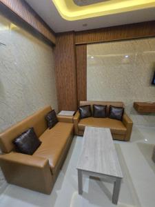 a living room with two couches and a table at Cozy Studio in Ghaziabad