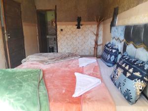a room with two beds and pillows on a bed at riad atlas imnane in Imlil +24 photos
