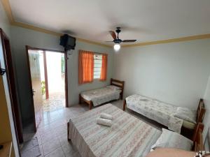a room with two beds and a ceiling fan at Pousada Rezende in Caldas Novas +16 photos