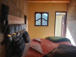 a bedroom with a bed in a room with a window at riad atlas imnane in Imlil