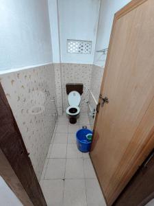 a bathroom with a toilet and a wooden door at White stays in Munnar