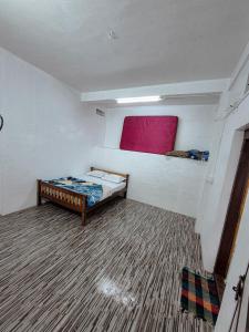 a small room with a bed and a red window at White stays in Munnar