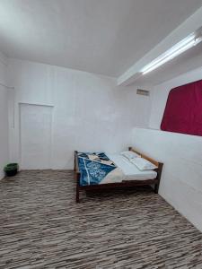 a bedroom with a bed in the corner of a room at White stays in Munnar
