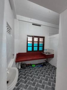 a bathroom with a red bench and a window at White stays in Munnar