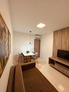 a living room with a table and a television at FLAT NO CONDOMÍNIO MONTE CASTELO MODULO 1 TÉRREO GRAVATÁ - Pe in Sairé