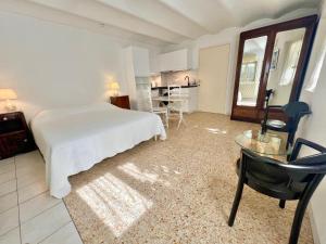 a bedroom with a bed and a desk and a table at Résidence La Villa Léonie in Nice