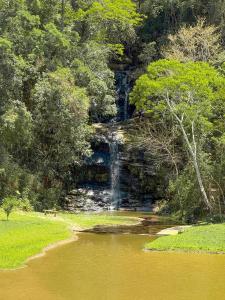 a waterfall in the middle of a body of water at Pousada Shangri-lá in Cunha +90 photos