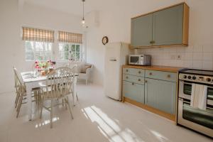 a kitchen with a table and chairs and a refrigerator at Butley Priory Cottage in Woodbridge