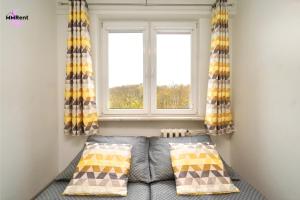 a living room with a couch and a window at MMRent Apartament CityLight in Gdańsk