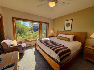 a bedroom with a bed and a window and a chair at Poplar River Condos in Lutsen