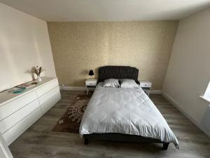 a bedroom with a bed with two night stands and two tables at appartement au premier étage in Thaon-les-Vosges