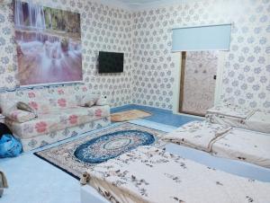 a living room with two beds and a couch at سوما للشقق المفروشه Soma apt in Al Madinah
