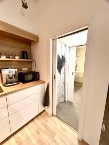 a kitchen with a door leading into a kitchen with a microwave at Ubytování v srdci Písku in Písek