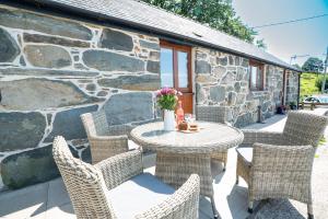TalsarnauにあるBeudy-Talsarnauの石壁のパティオ(テーブル、椅子付)