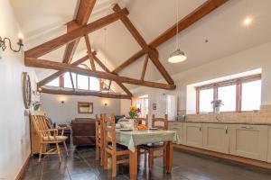 TalsarnauにあるBeudy-Talsarnauの木製の梁のあるキッチン&ダイニングルーム