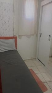 a small bedroom with a bed and a door at Apê da VAN in Garanhuns