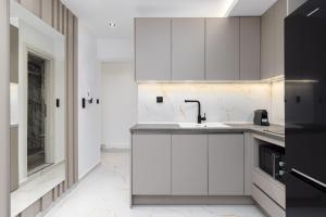 テッサロニキにあるAmelie Studios by halu!の白いキャビネットとシンクのあるキッチン