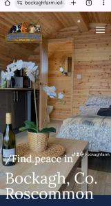 1 dormitorio con 1 cama y 1 botella de vino en Bockagh Farm, en Ballaghaderreen