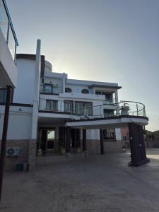un gran edificio blanco con un balcón en un aparcamiento en JD Hotel, en Accra
