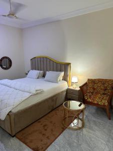 Un dormitorio con una cama, una silla y una mesa. en JD Hotel, en Accra