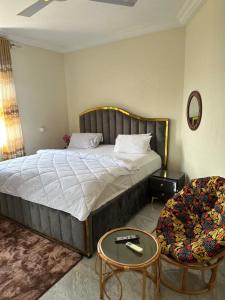 a bedroom with a large bed and a table at JD Hotel in Accra
