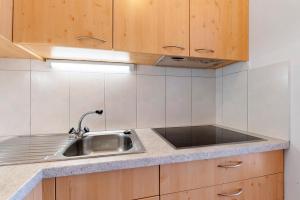 Una cocina con fregadero y armarios de madera. en Zolerhof, en Velturno 124 fotos más