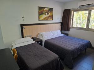 a hotel room with two beds and a window at Hotel 170 in Castelldefels