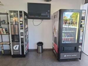 two soda machines with a television on the wall at Hotel 170 in Castelldefels