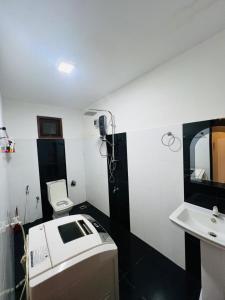 Un baño blanco con lavabo e inodoro. en Weligama Surf Villa, en Weligama