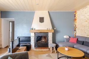 a living room with a couch and a fireplace at Longère de charme avec piscine, proche océan in Lairoux