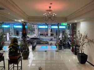 a lobby with a car dealership with motorcycles in it at Two Chung Hotel in Tucheng