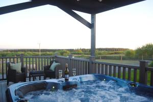 una bañera de hidromasaje en una terraza con una botella de vino en Bockagh Farm, en Ballaghaderreen 18 fotos más