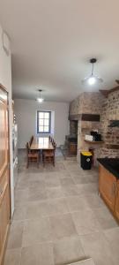 une salle à manger avec une table et un mur en pierre dans l'établissement Maison de village ardéchoise Les Ruches, à Chalencon