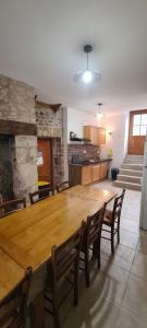une cuisine avec une table en bois et quelques chaises dans l'établissement Maison de village ardéchoise Les Ruches, à Chalencon