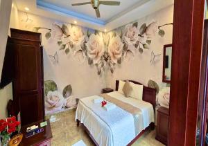 a bedroom with a bed and flowers on the wall at Lys Homestay in Ninh Binh
