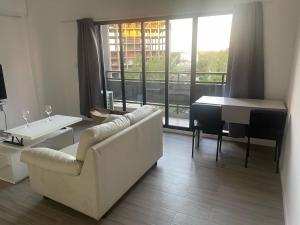 a living room with a couch and a table and a piano at Hermoso depto en Puerto Santa Fe Portofino in Santa Fe