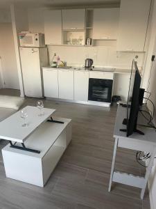 a kitchen with white cabinets and a television on a table at Hermoso depto en Puerto Santa Fe Portofino in Santa Fe