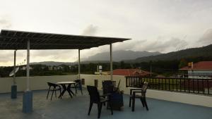 奇克马格尔Shrivari Homestay的屋顶上带桌椅的天井