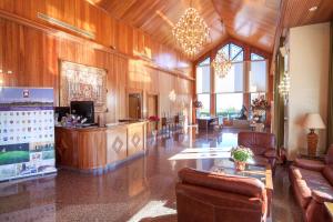 Un amplio vestíbulo con paredes y muebles de madera y ventanas en Apartamentos Lomas De Campoamor, en Campoamor