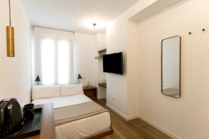 a small bedroom with a bed and a mirror at Colectia Stays Atocha in Madrid