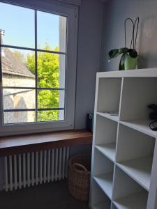 ein Regal in einem Raum mit einem Fenster in der Unterkunft Clos St Vaast près plage et port in Saint-Vaast-la-Hougue