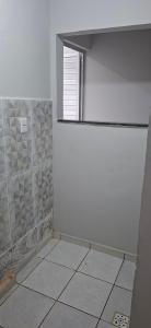 a bathroom with a window and a tiled floor at Apartamento in Belém